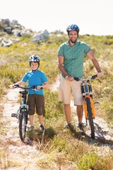 Obraz premium Father and son biking through mountains