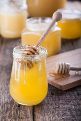 Honey in a jar with a wooden honey dipper.