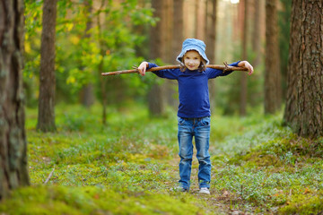 Adorable girl picking foxberries in the forest