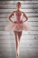 Composite image of pretty ballerina in pink standing en pointe