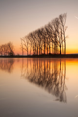 Fototapeta na wymiar Symmetry on the river at sunrise
