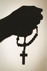 Hand holding rosary beads