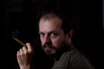Man with beard and mustaches, smoking the cigar