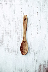 Olive wood spoon on a white painted surface