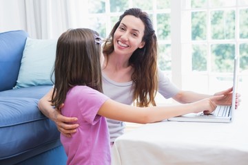 Mother and daughter using laptop