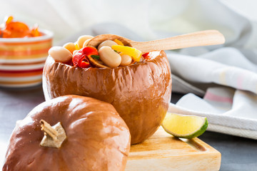 White bean and red pepper stew in pumpkin bowls .