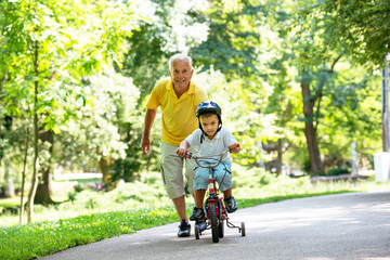 grandfather and child in park using tablet