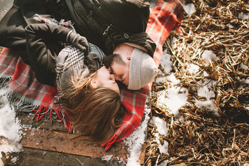 Couple close lying on plaid in winter park