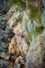 Rock climber climbing up a cliff