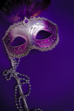 Purple Mardi-Gras or Venetian mask on purple background