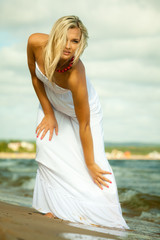 Fototapeta na wymiar Beautiful blonde girl on beach, summertime