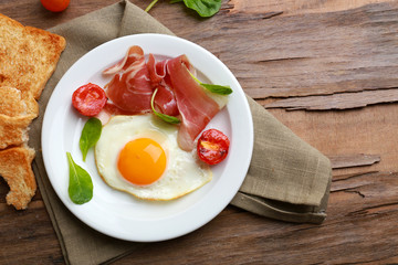 Bacon and eggs on rustic wooden planks background
