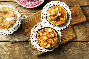 Mini cakes with nuts on wooden background