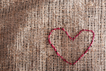 Linen canvas with red heart embroidered on it, close-up