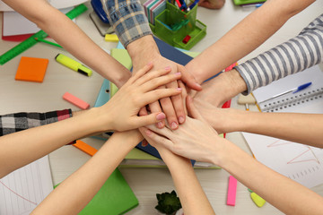 United hands of business team on workspace background top view