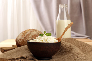 Tasty dairy products with bread on table on fabric background