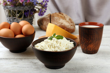 Tasty dairy products with bread and dry flowers