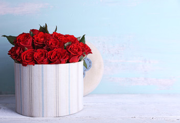 Bouquet of red roses in textile box on wooden background