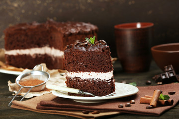 Delicious chocolate cake on table on brown background
