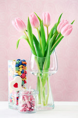 Beautiful pink tulips with sweets in vase