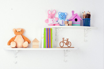Fototapeta na wymiar Shelves with toys in child room close-up