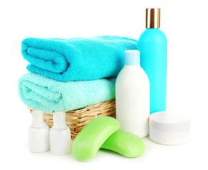 Fototapeta na wymiar Towels in wicker basket with shampoo bottles and soap isolated