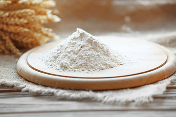 Pile of flour on cutting board with burlap cloth, closeup