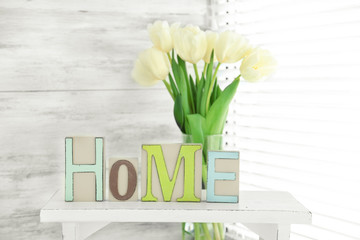 Home in colorful letters and spring flowers in light white