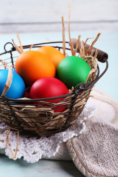 Easter eggs in basket on wooden background