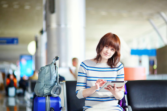 Young passenger at the airport, using her tablet