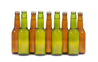 Row or line of green and brown beer bottles isolated on white background photo