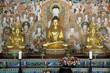 Fototapeta na wymiar Buddha with disciples and decorative painting Buddhist temple display photo