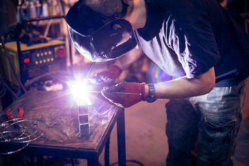 Employee welding aluminum using TIG welder in workshop. - obrazy, fototapety, plakaty