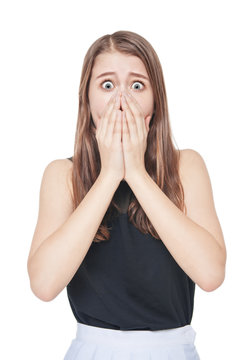 Young scared teenage girl covering her mouth with hand isolated