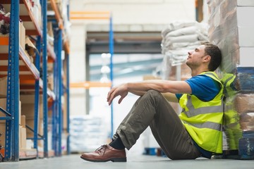 Tired manual worker sitting on floor