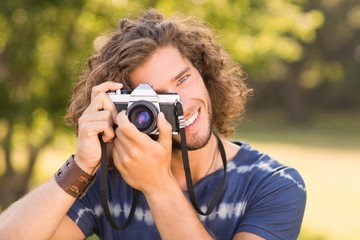 Handsome hipster using vintage camera