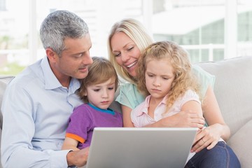 Fototapeta na wymiar Parents using laptop with children