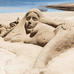 Meerjungfrau aus Sand liegt am Strand