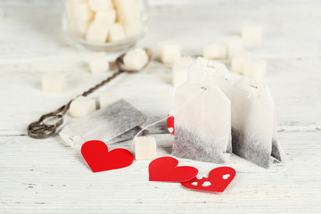 Heart shaped teabag tags on wooden background