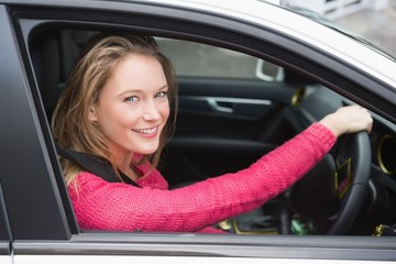 Fototapeta na wymiar Young woman driving and smiling