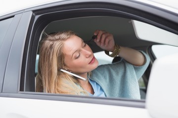 Young woman putting on makeup while calling