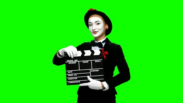 Woman mime uses the movie clapper on green screen