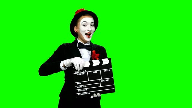 Woman mime uses the movie clapper on green screen