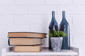Interior design with plant, glass bottles and stack of books