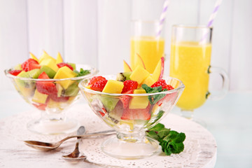 Fruit salad with mint and orange juice in glassware
