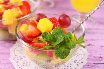 Fruit salad with mint and orange juice in glassware