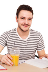 Young man sitting at the table with a pile of books