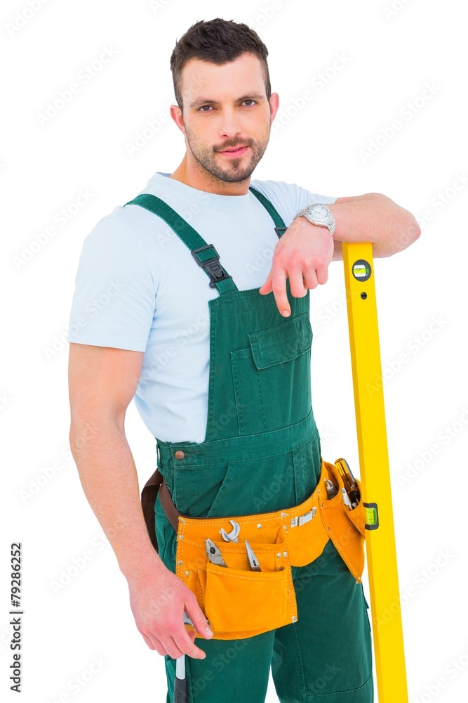 Poster carpenter smiling to camera with spirit level