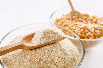 Glass bowls with flour and corn grains close up