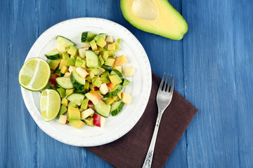 Salad with apple and avocado in bowl on table close up